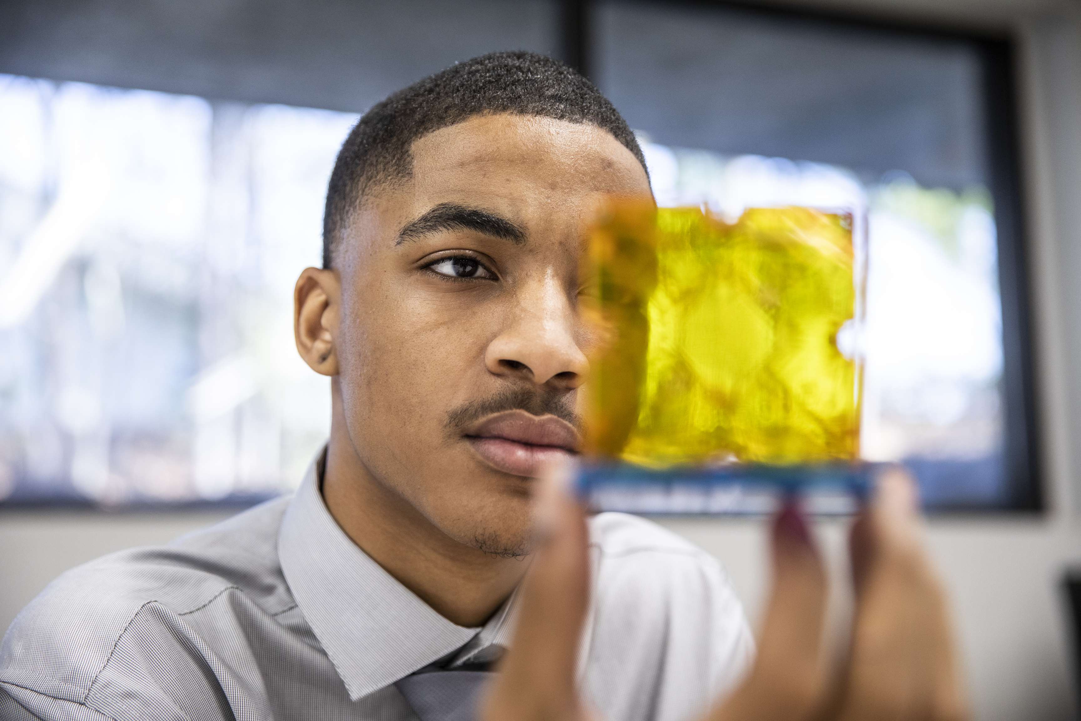 Employee looking thoughtful at yellow glas cube.