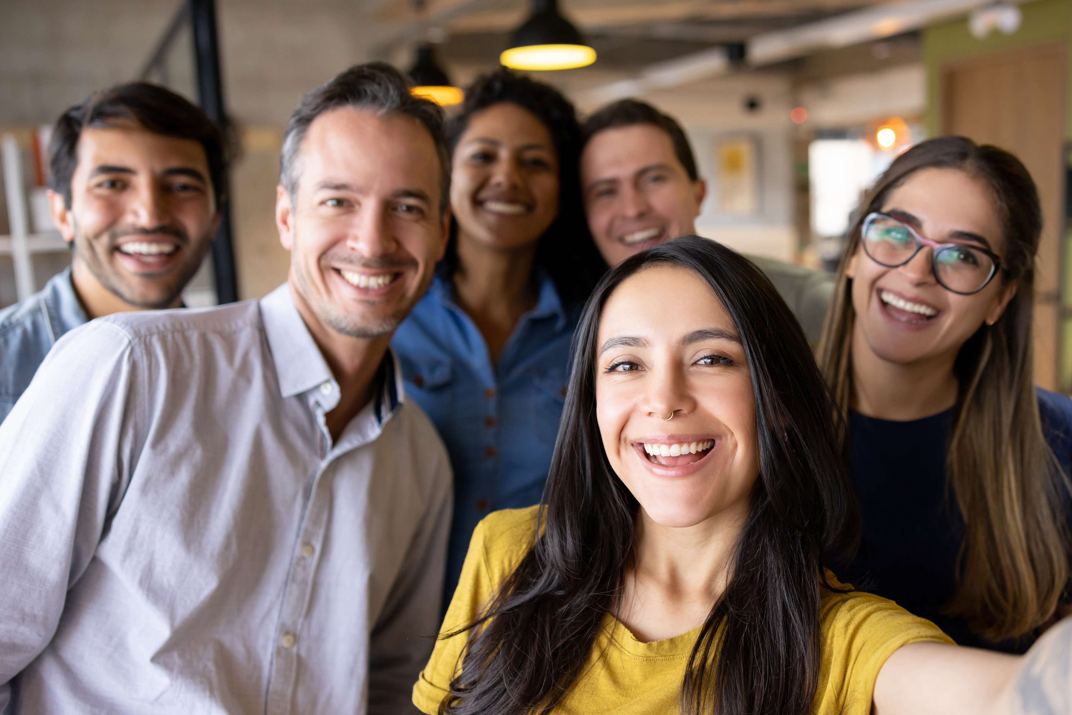 A group of people laughing while taking a photo of themselves.