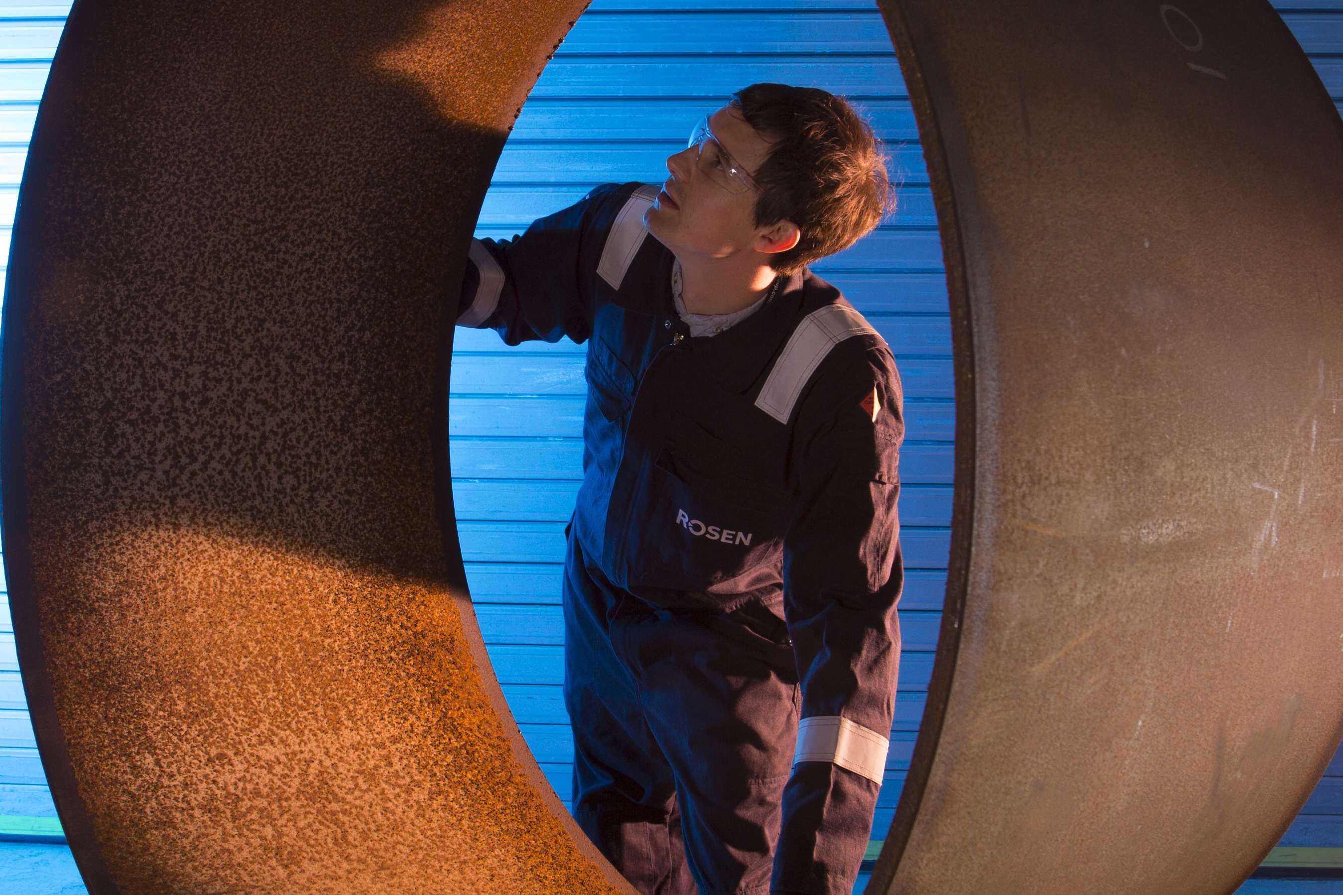 Shot from inside a pipeline of an employee looking at the inner surface.
