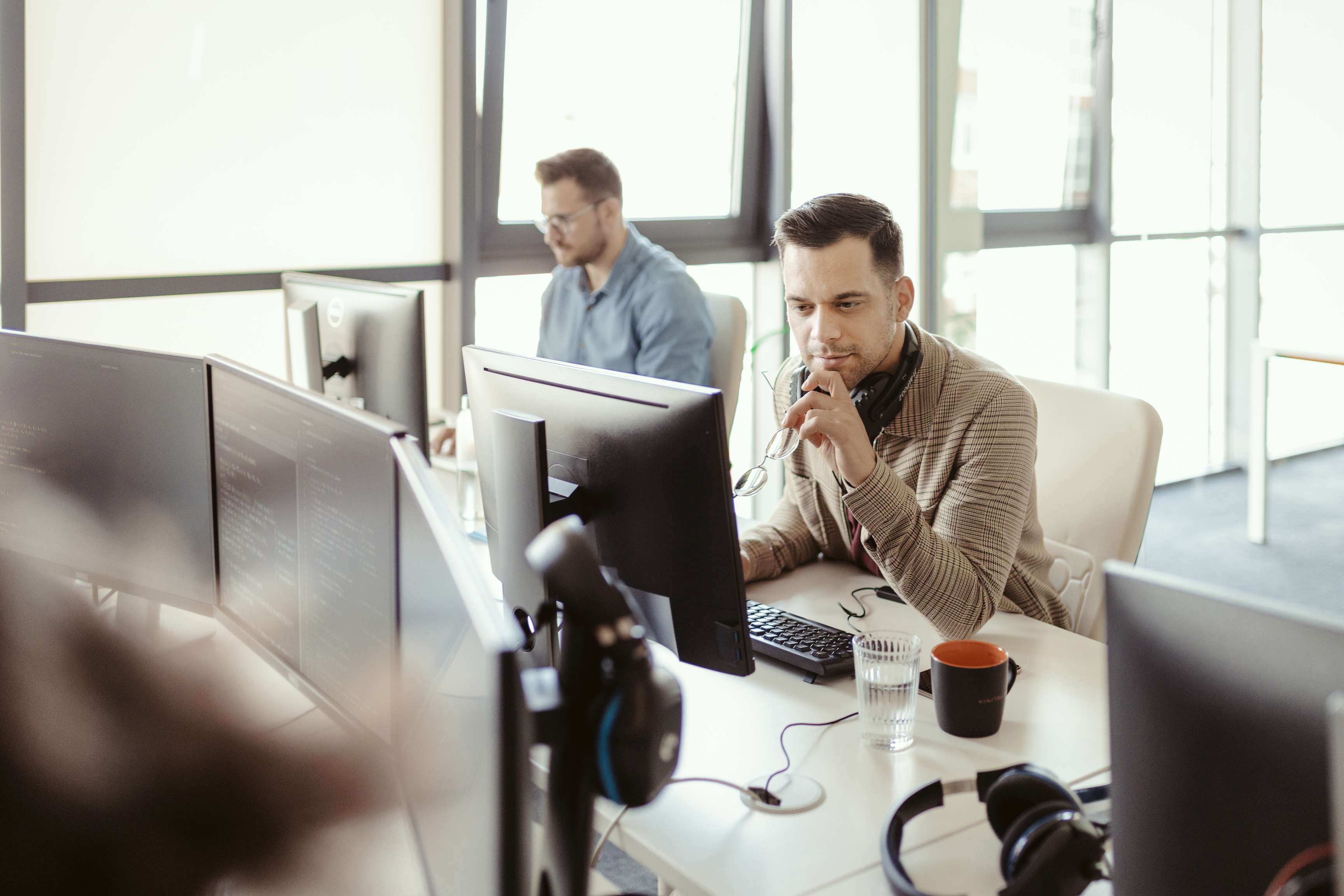 Image of data analysts sitting at their computers working.