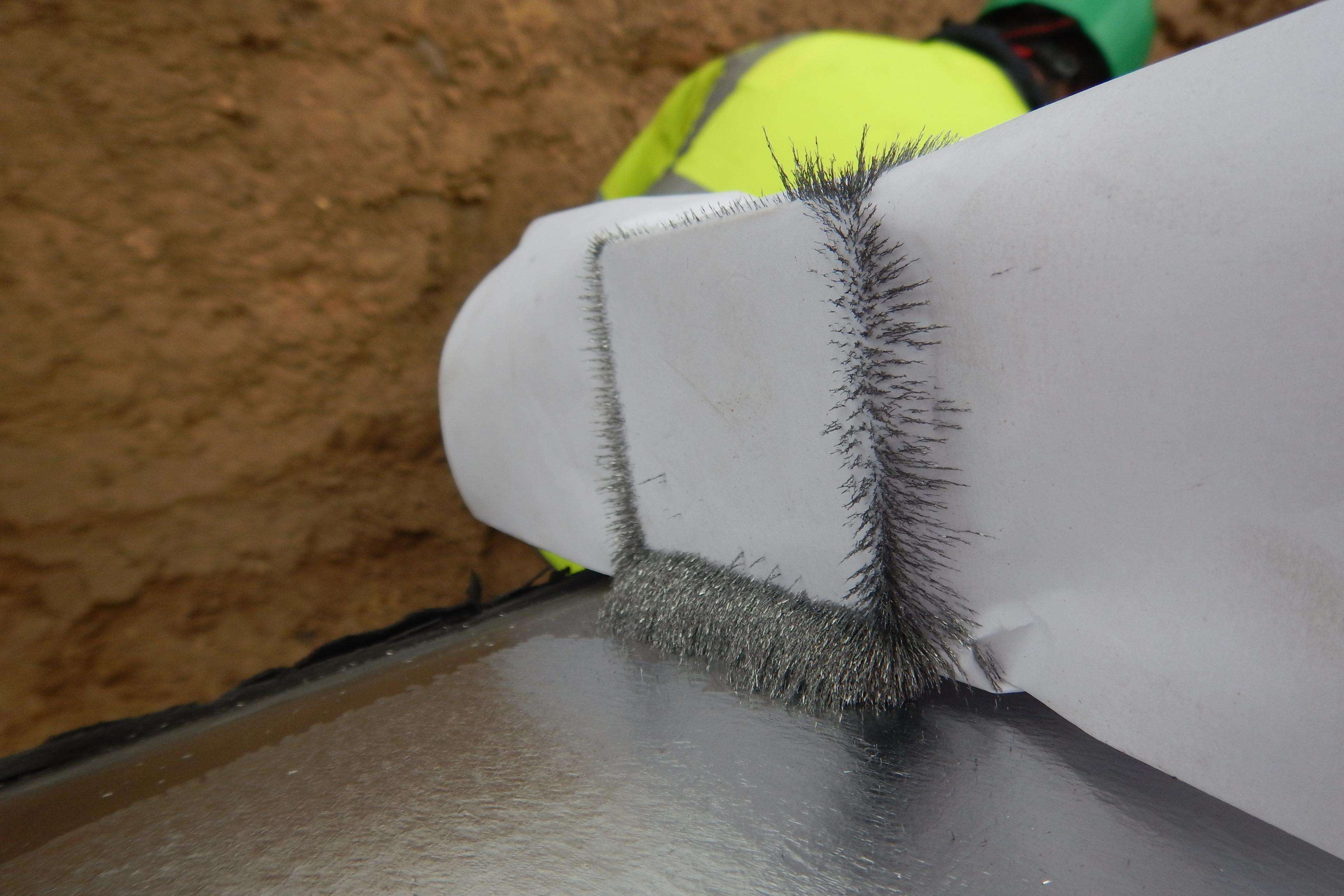 Close-up of a magnet on a pipeline with tiny metal parts on it.