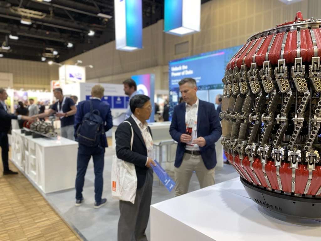 This photo shows a ROSEN employee and a prospect at the ROSEN booth in front of a tool at PTC 2025.