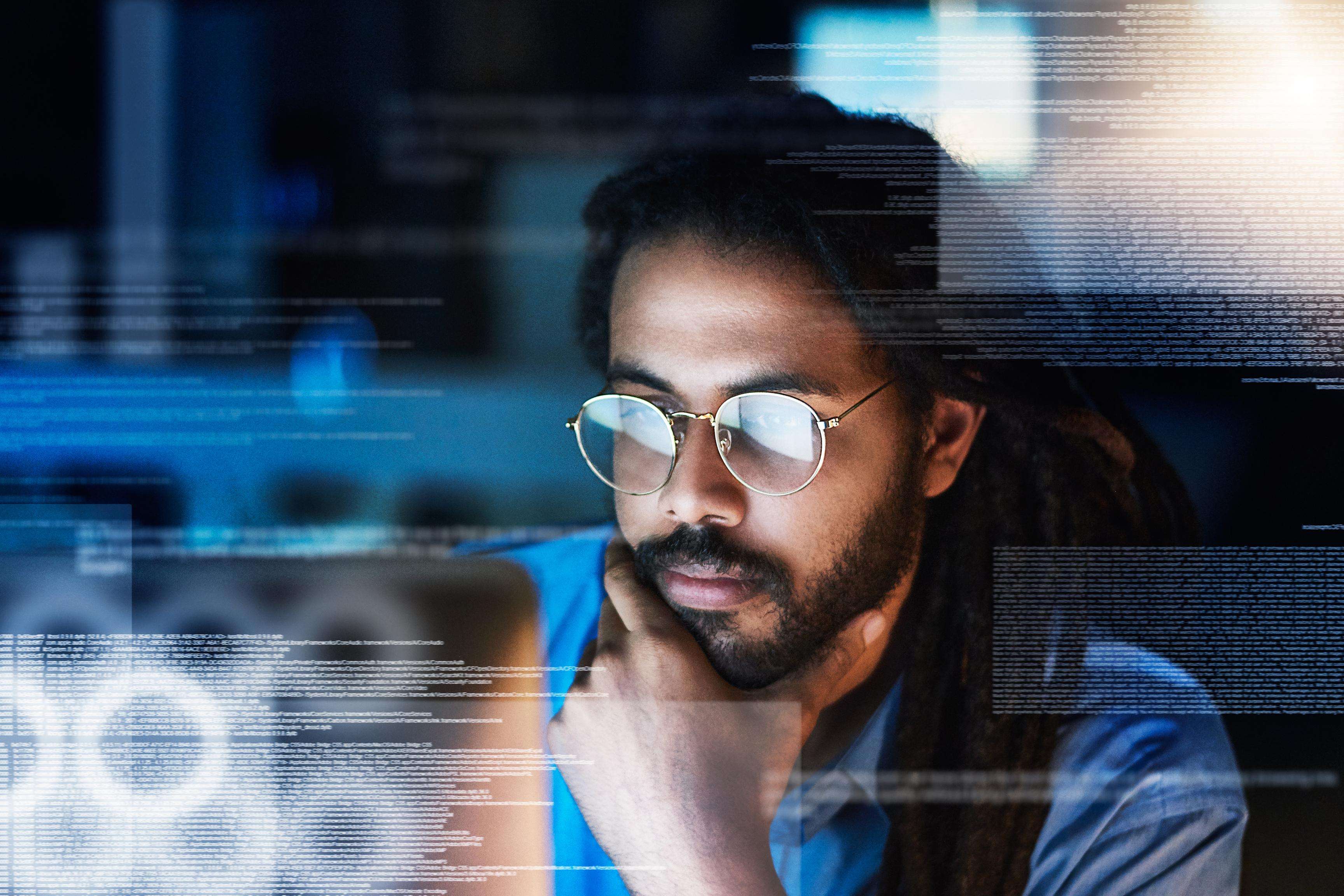 Man wearing glasses looking at screens