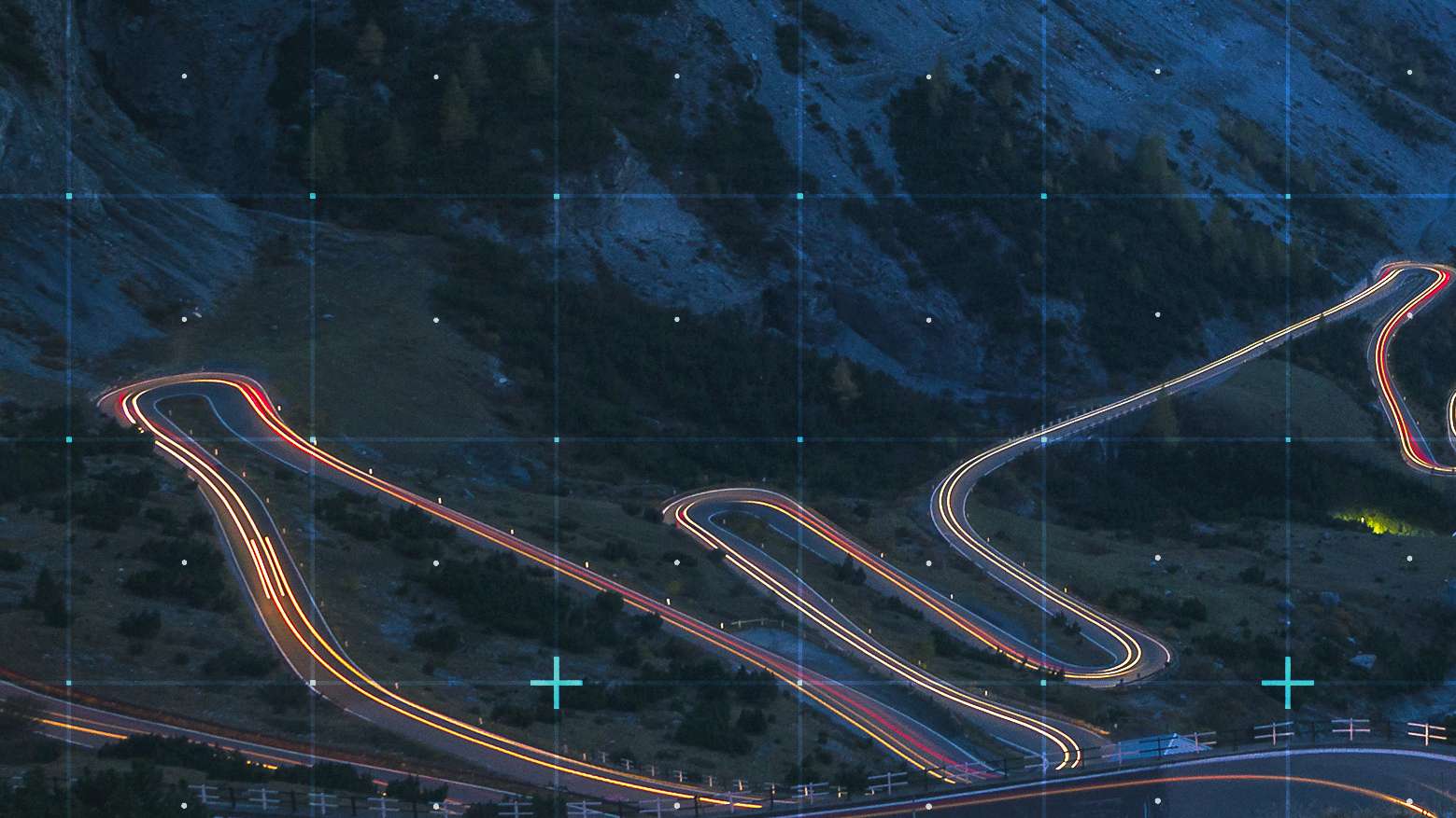 Rasterized view of dark mountain landscape with lighted road passing through it.