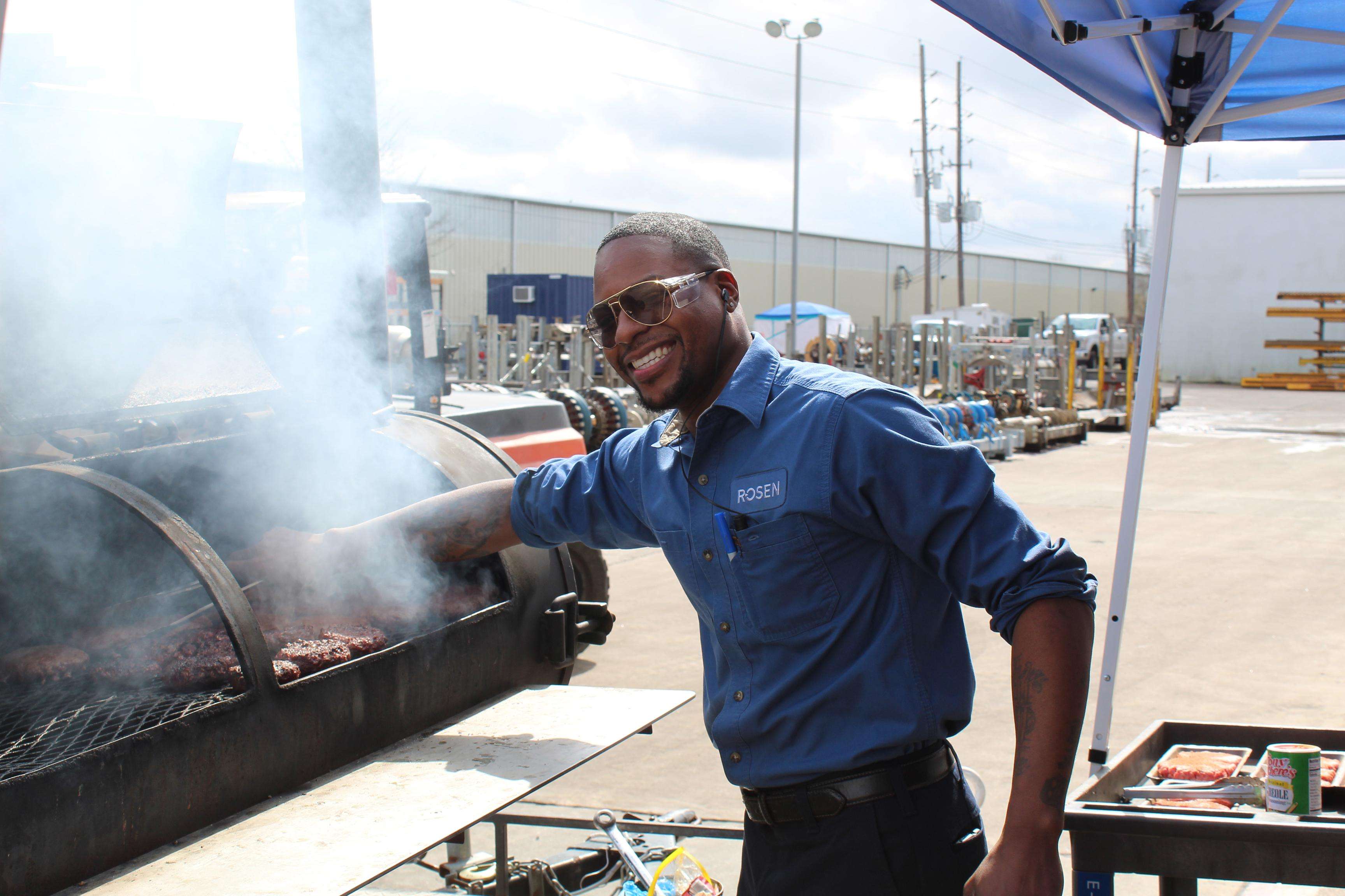 Man in ROSEN shirt having a barbecue at a ROSEN site.