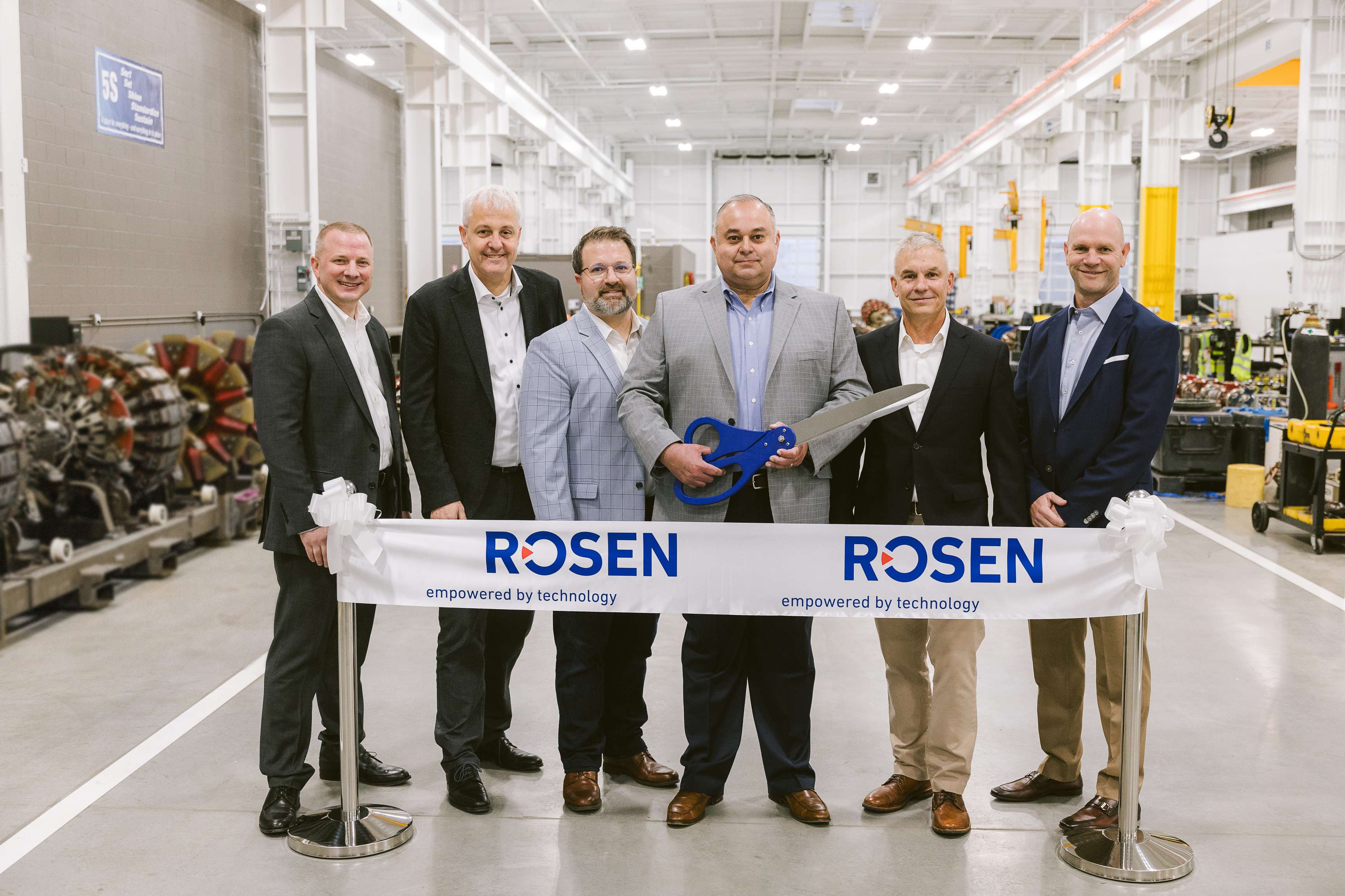 A group picture in the new opened ROSEN facility in Gahanna, Ohio with five men standing behind the ribbon.