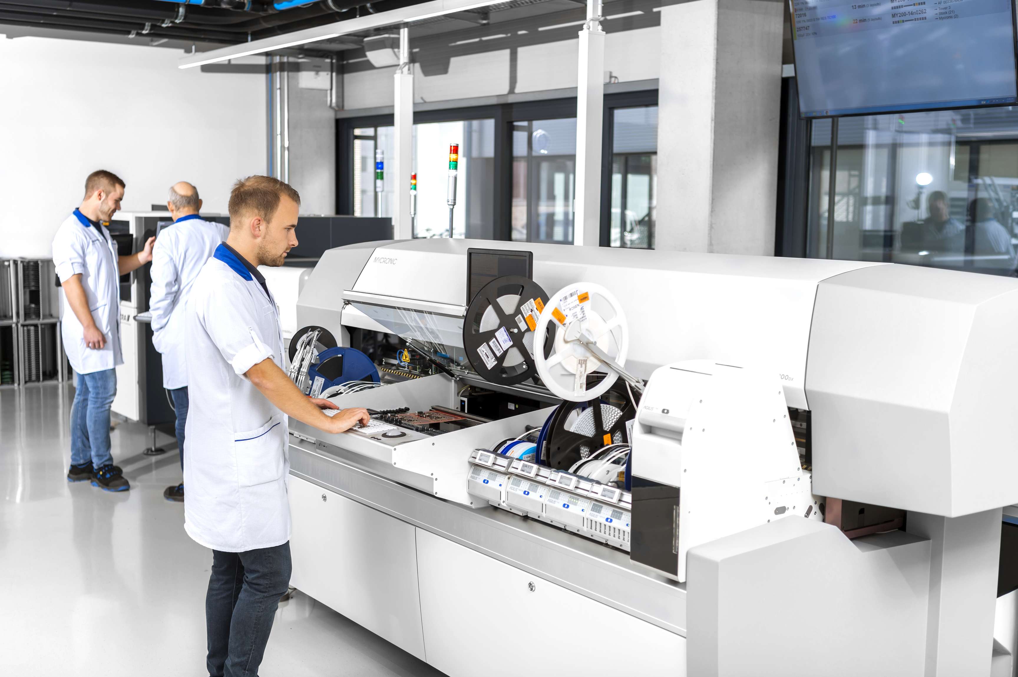 Mitarbeiter an den Maschinen in der Elektronikfabrik.