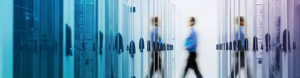 Man and its reflection through a corridor with glass lockers.