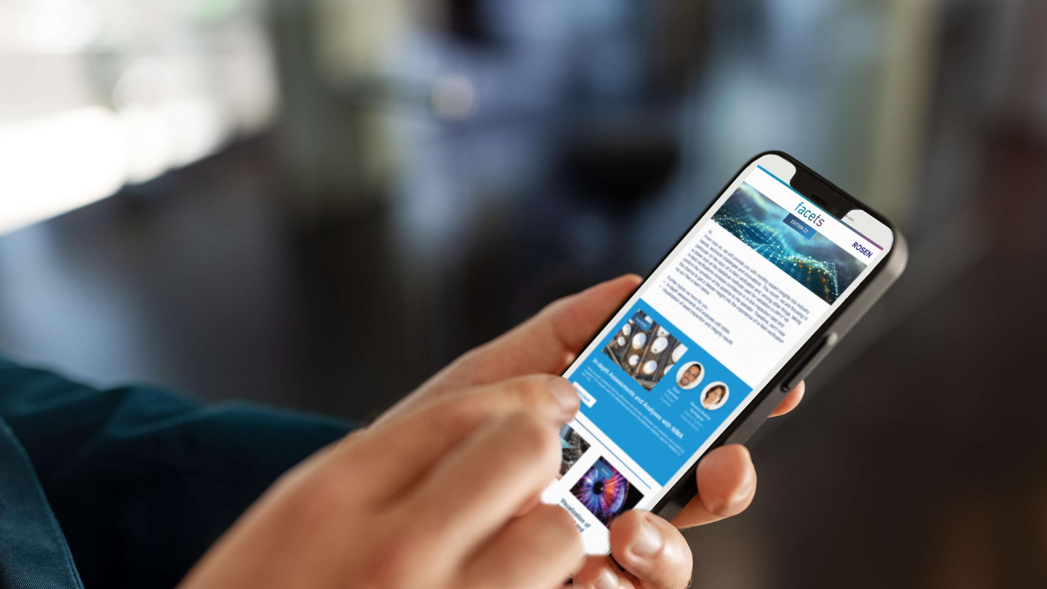 Close up of a hand holding a cell phone on which the facet newsletter can be seen.