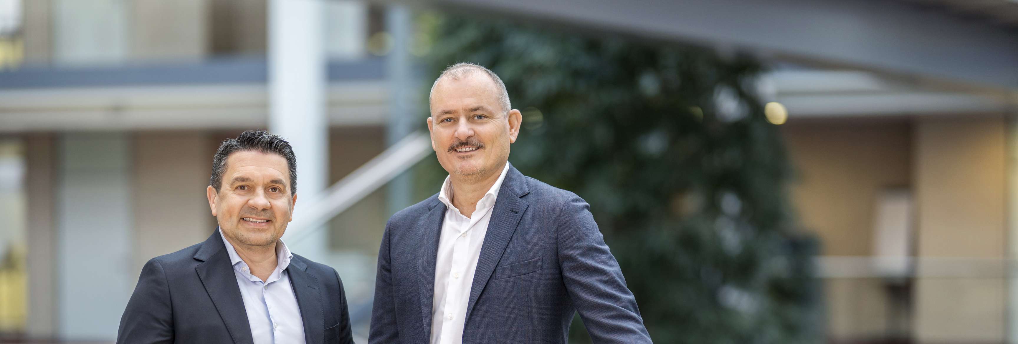 The picture shows Erik Cornelissen and Roland Kampe standing together on the Skywalk in the Rotrium and smiling at the camera.