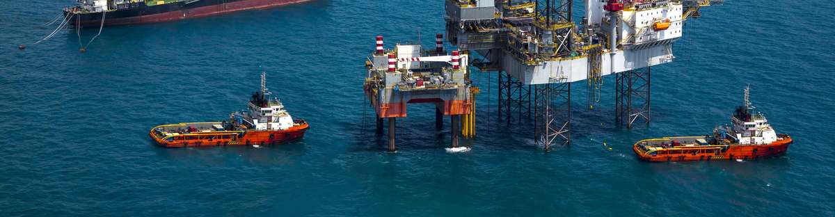 Offshore platform with tanker and other vessels surrounding it.