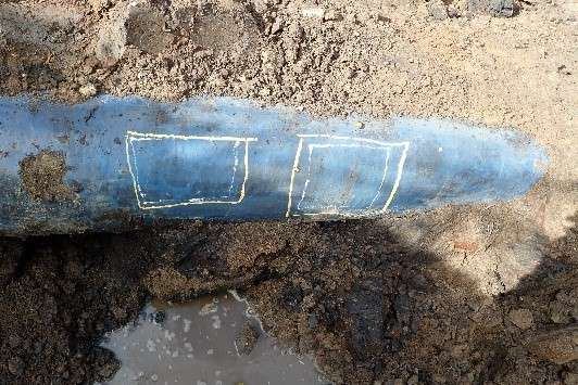 Excavated pipeline with yellow markings to show locations of minor coating defects and light surface corrosion.