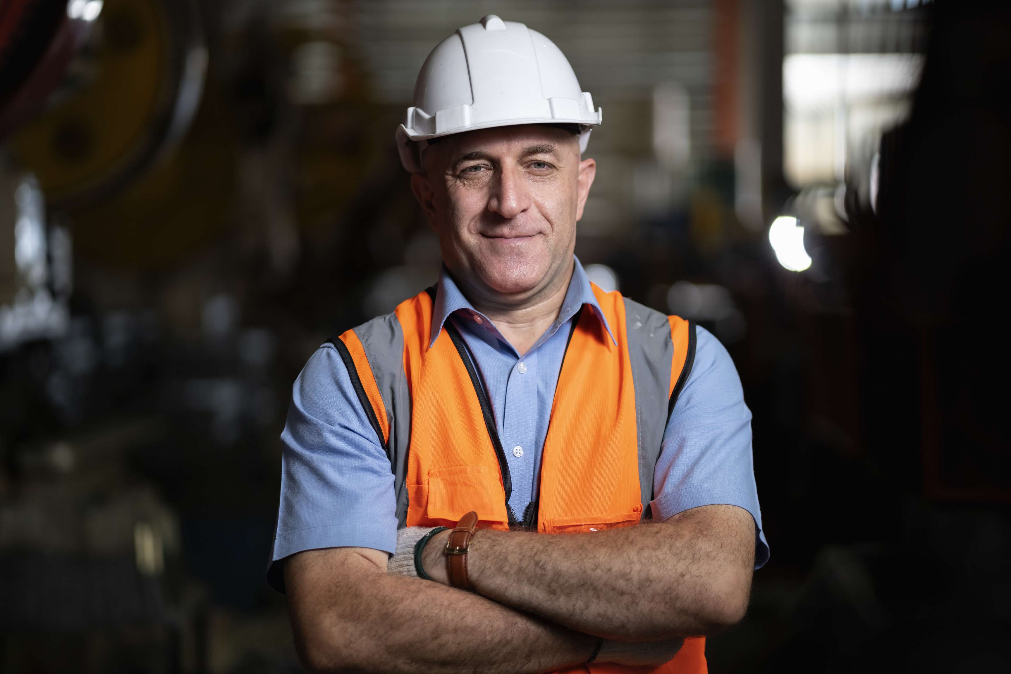 Man wearing a short-sleeved shirt, a safety vest and a safety helmet.